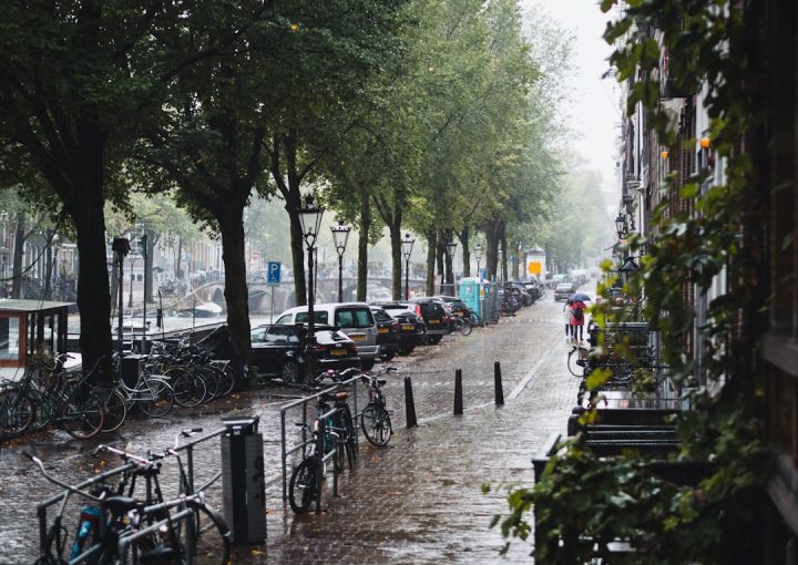 people walking on sidewalk with bicycle parked on sidewalk during daytime
